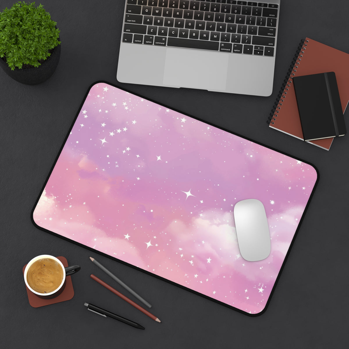 Pink Galaxy desk mat on a dark desk with a laptop and mouse