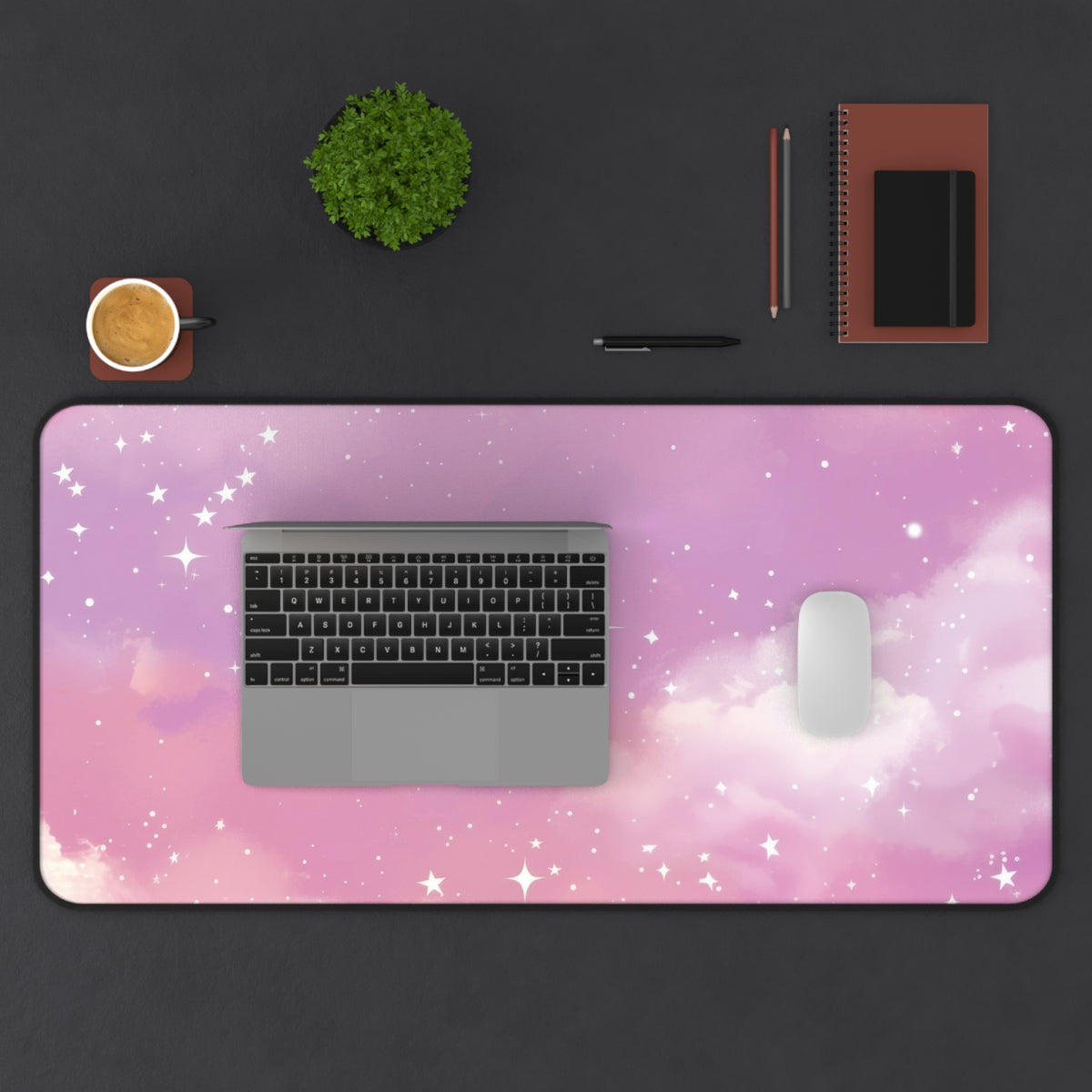 Pink Galaxy desk mat from above with a laptop and mouse on a dark desk