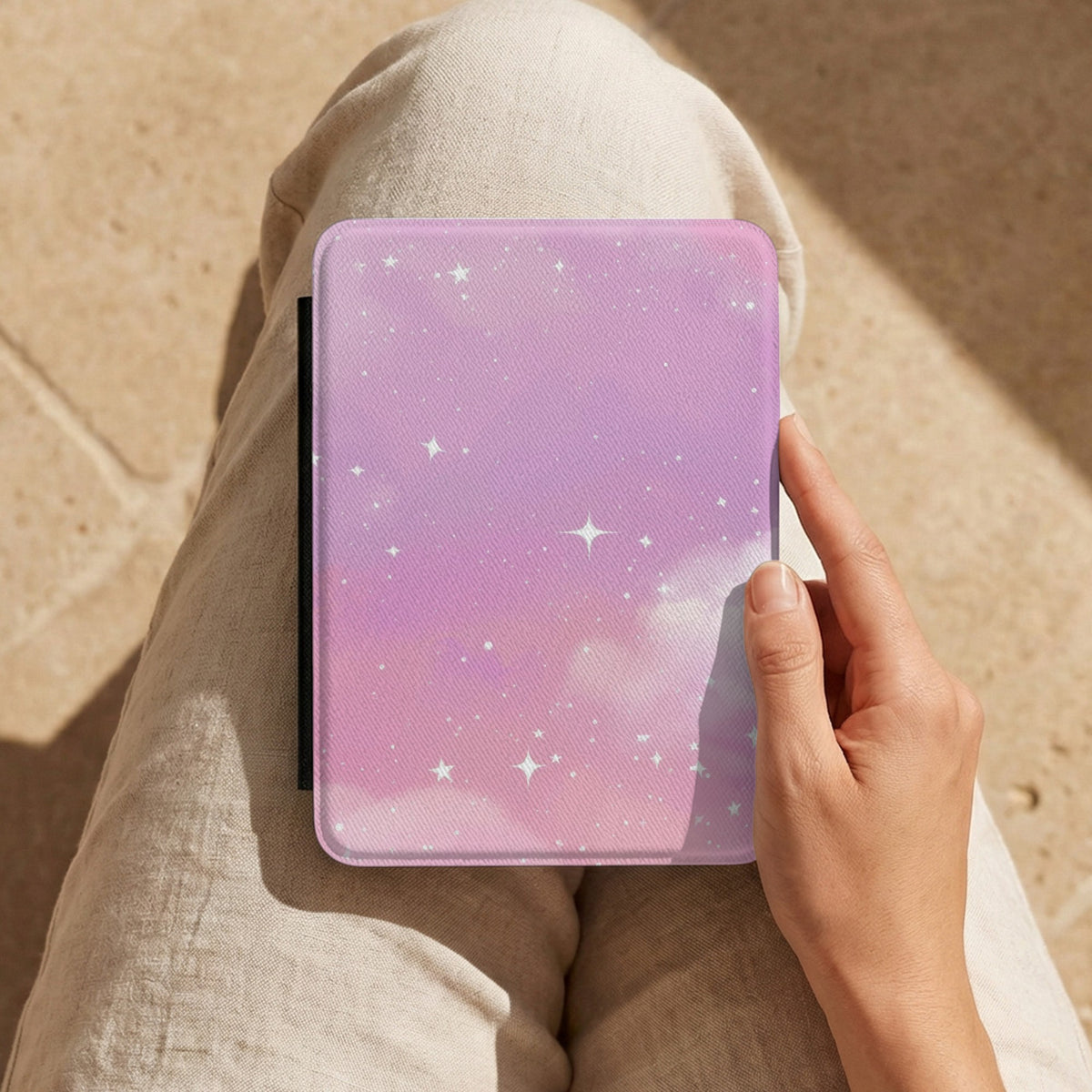 Pink Galaxy Kindle case held on a lap while reading