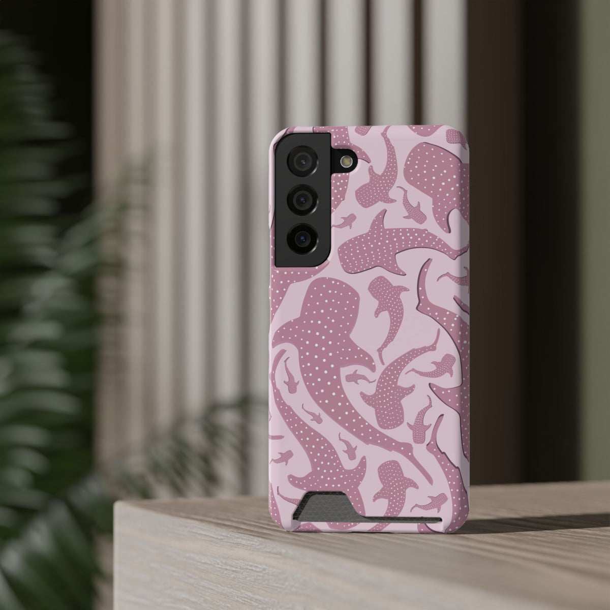 Pink Whale Shark phone case with card holder standing on a shelf