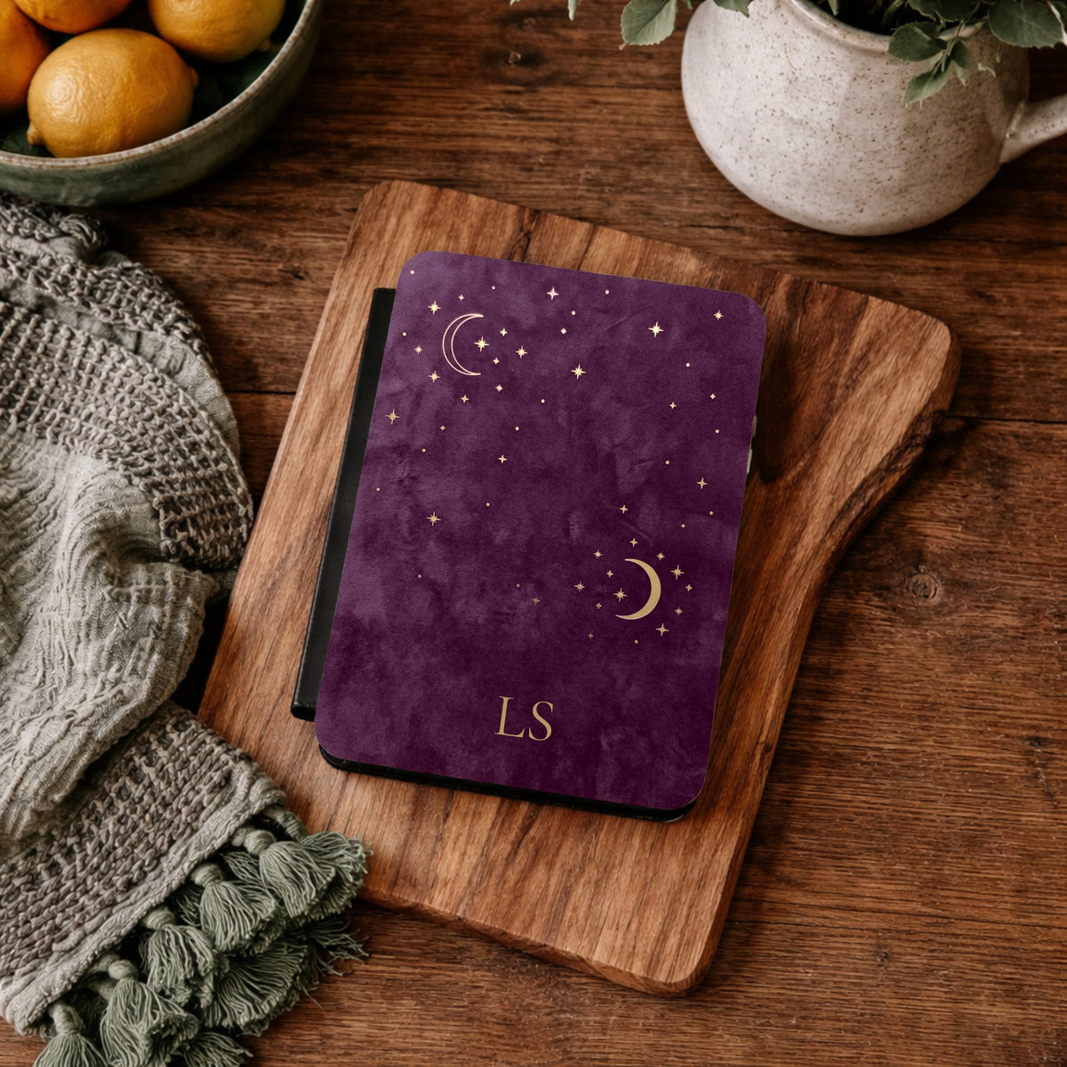 Plum Crescent Moon Kindle case with initials on a wooden board beside a knit