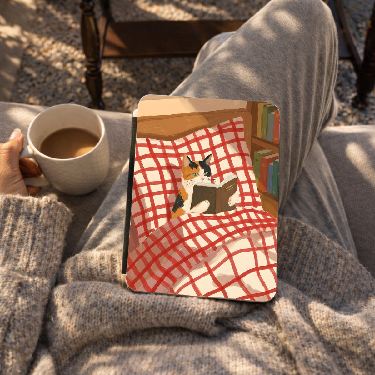Reading Cat Kindle case on a lap next to a cup of coffee