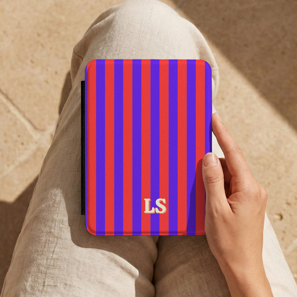 Red Cabana Stripe Kindle case with initials held on the lap