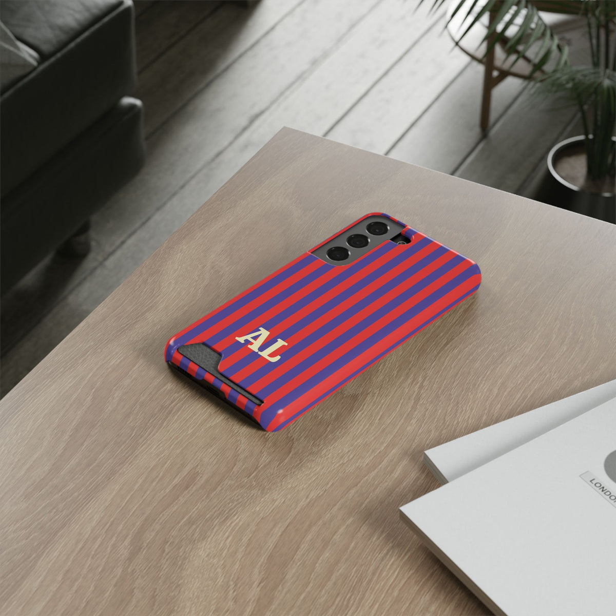 Red Cabana Stripe card holder phone case on a wooden table