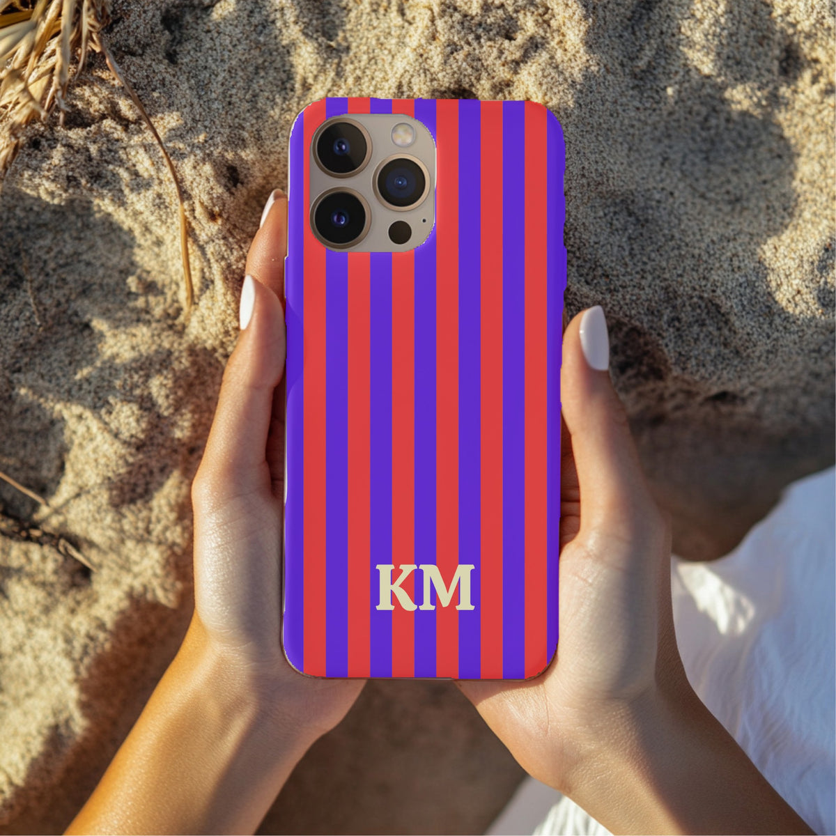 Red Cabana Stripe tough phone case held over sand at the beach