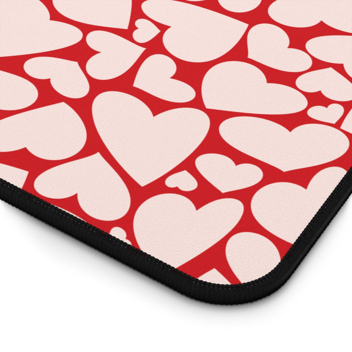 Close-up of the red hearts print and the stitched edge