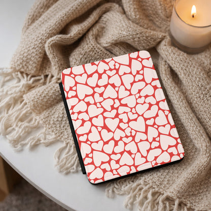 Red hearts Kindle case on a cream throw beside a lit candle