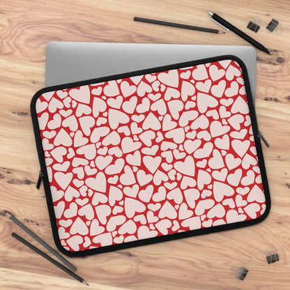 Red hearts laptop sleeve on a wooden desk with a laptop