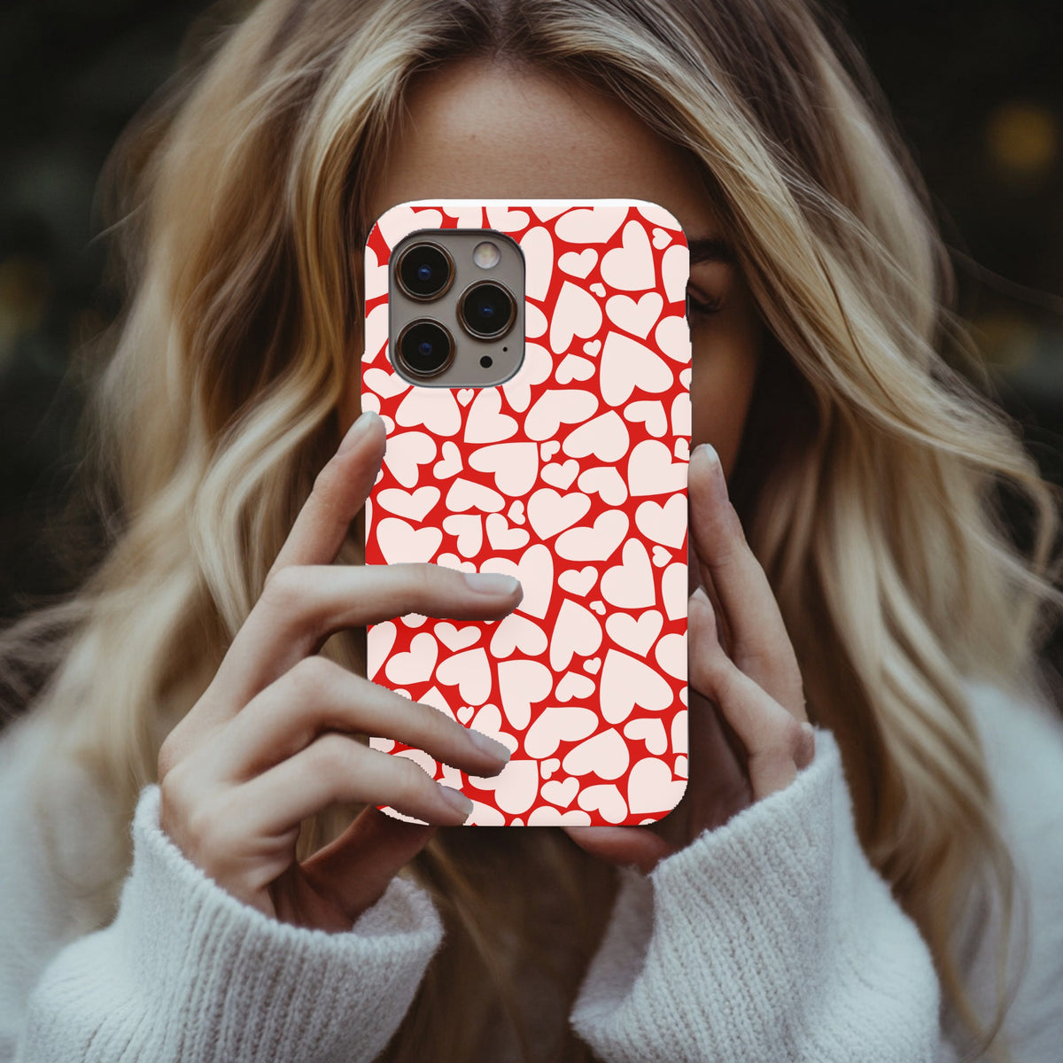 Red Hearts tough phone case held up in a mirror selfie