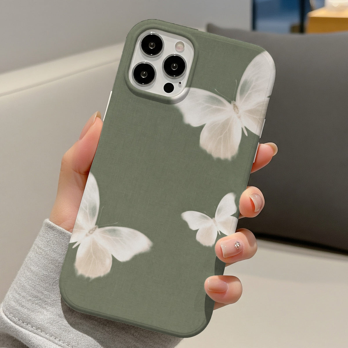 Sage Butterfly tough phone case held in hand on a sofa