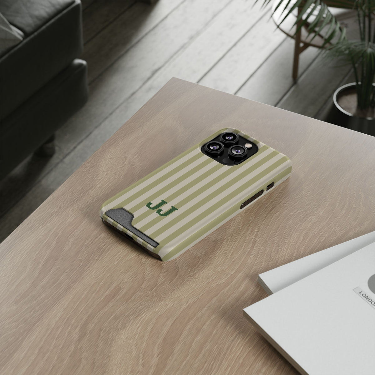 Sage Cabana Stripe card holder phone case on a wooden desk