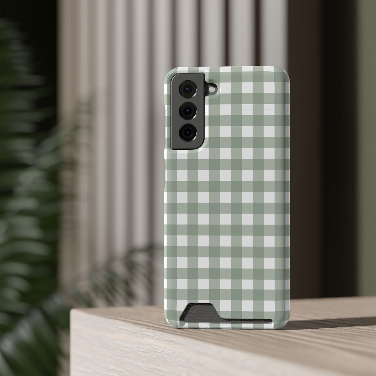 Sage Gingham card holder phone case standing on a table