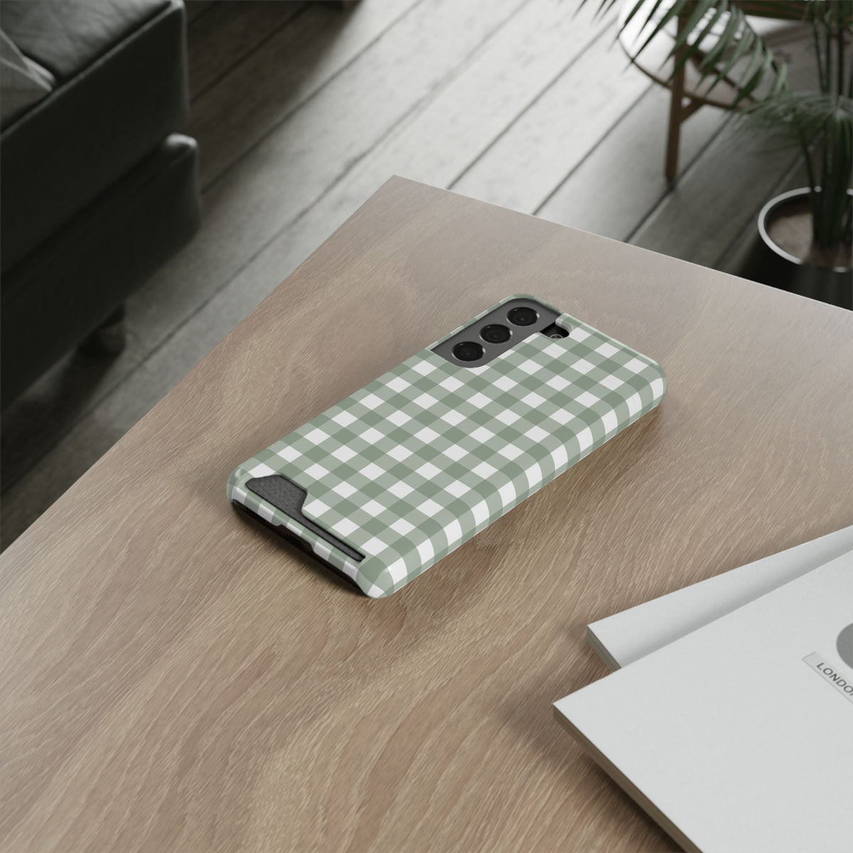 Sage Gingham card holder phone case lying on a wooden desk