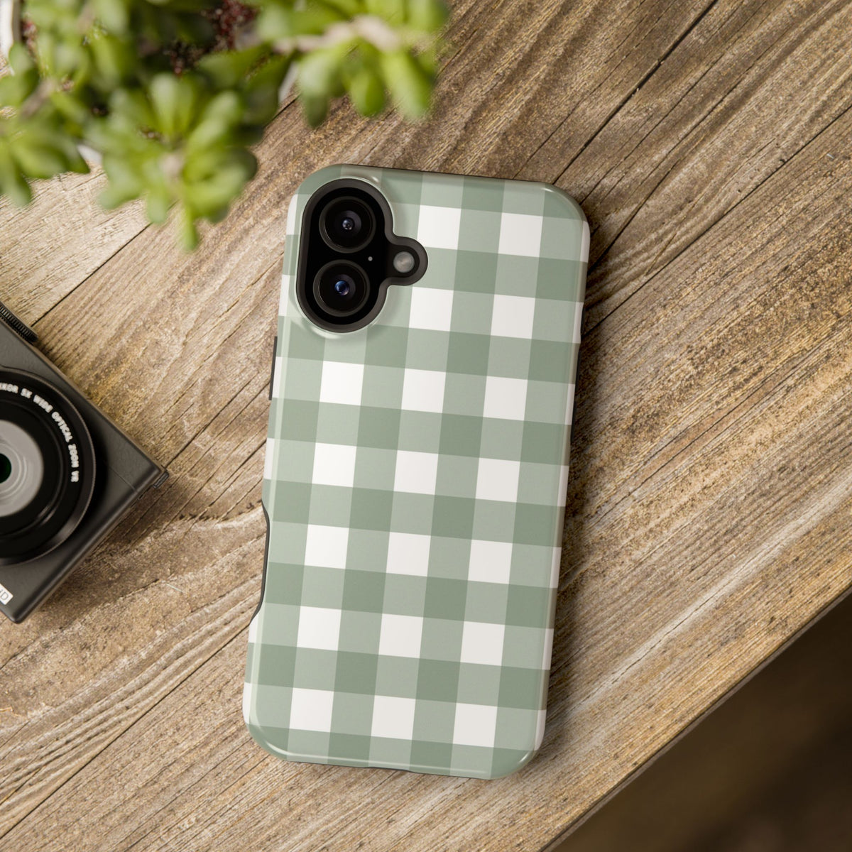 Sage Gingham MagSafe phone case lying on a wooden table