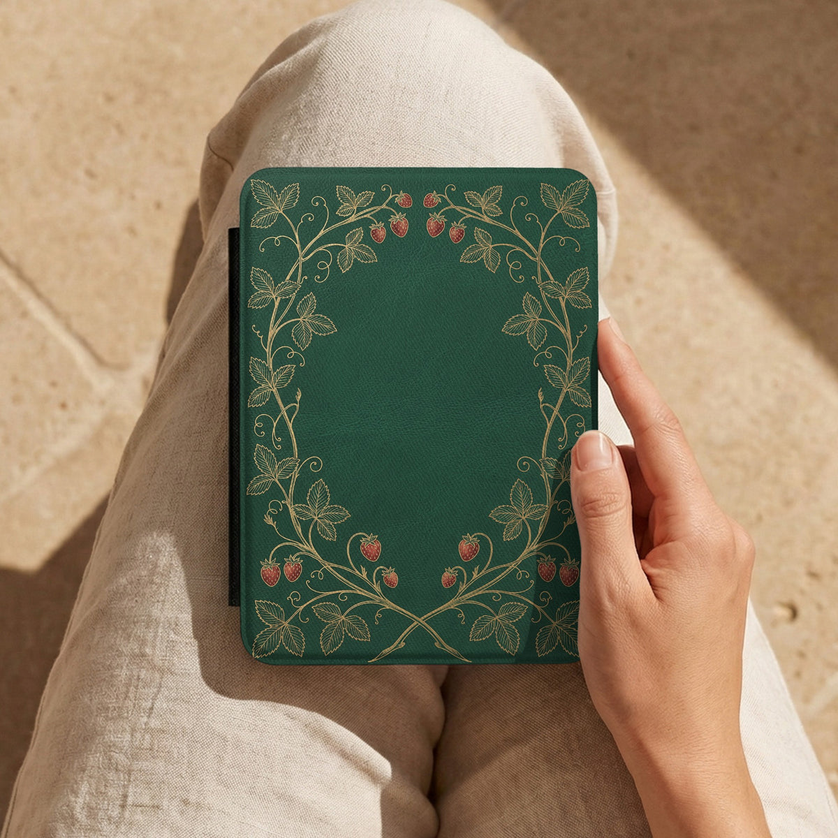 Strawberry Vine Kindle case held on a lap