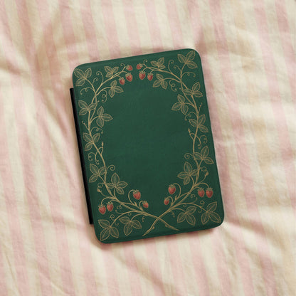 Strawberry Vine Kindle case lying on pink striped bedding