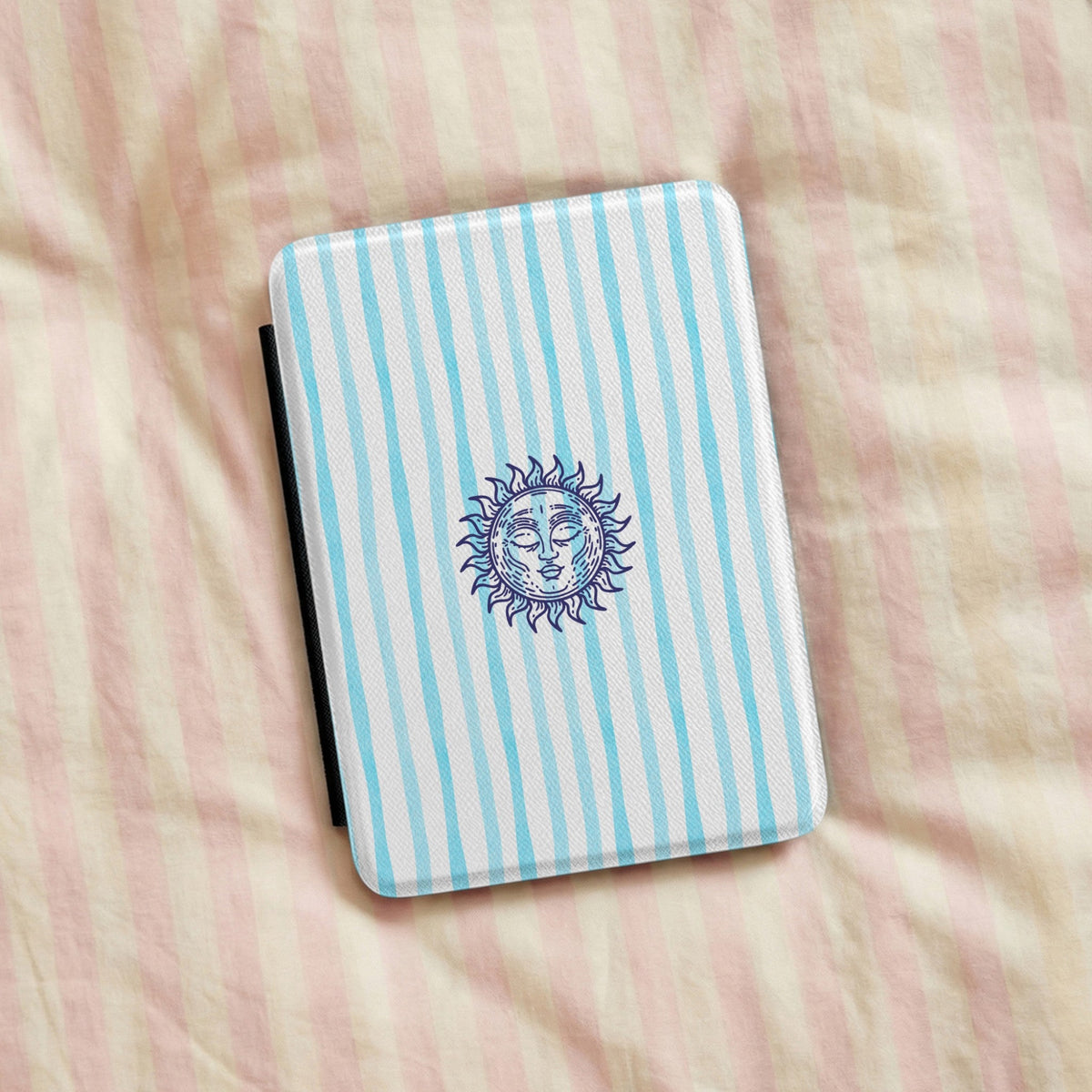 Sunny Striped Blue Kindle case resting on striped bedding