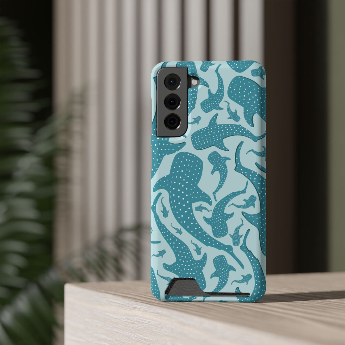 Teal Whale Shark phone case with card holder standing on a shelf