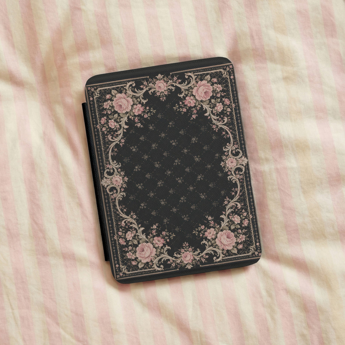 Victorian Rose Kindle case resting on pink striped linen bedding