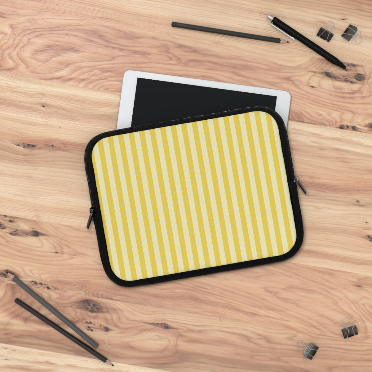 Yellow Cabana Stripe laptop sleeve on a wooden desk with a tablet